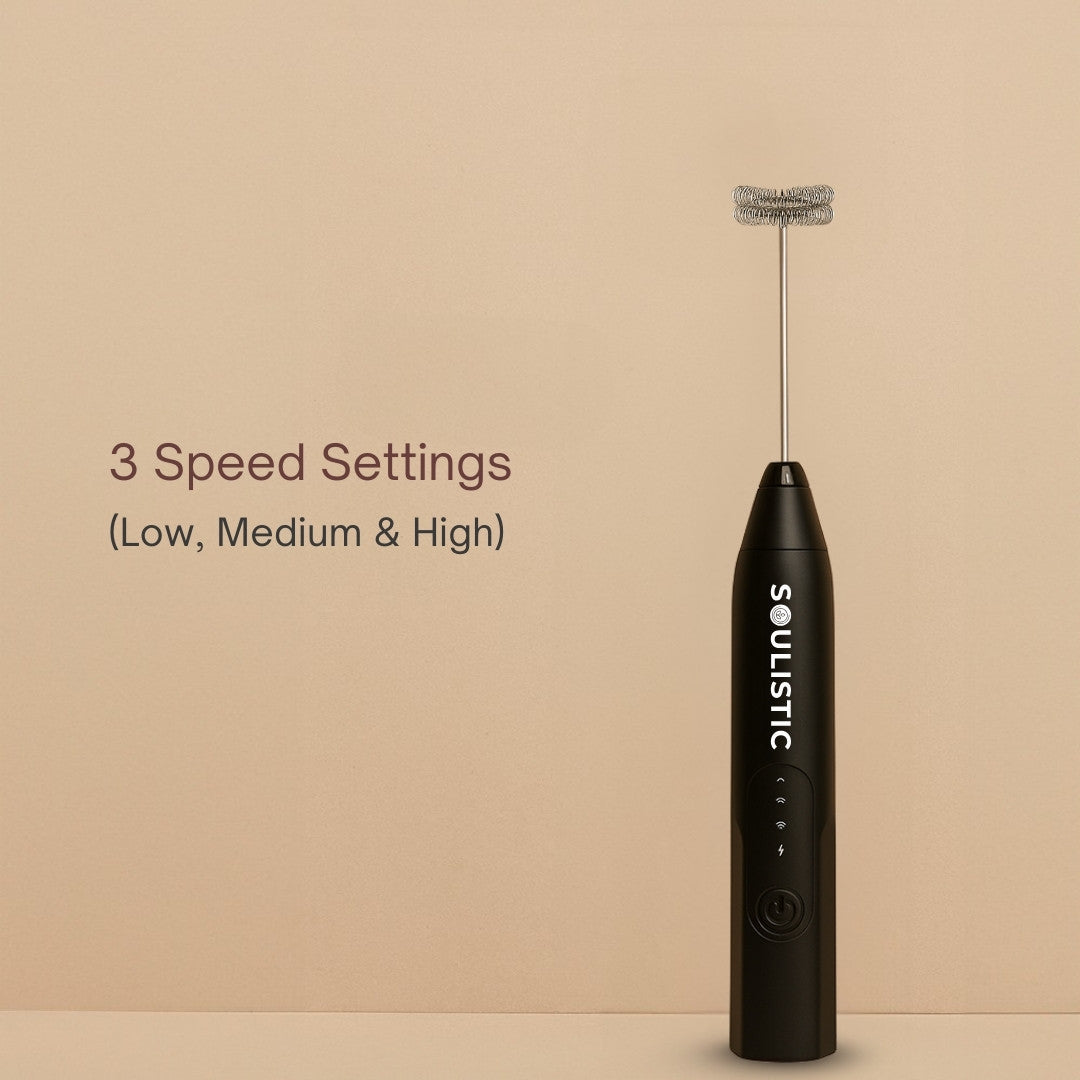 Black milk frother with 'Soulistic' branding on a beige background