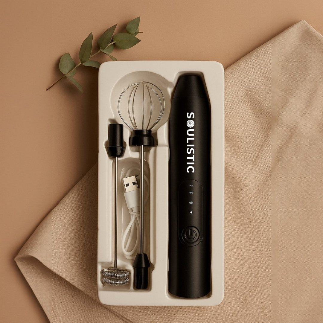 Black handheld Coffee Frother with whisk and USB cable on a beige background