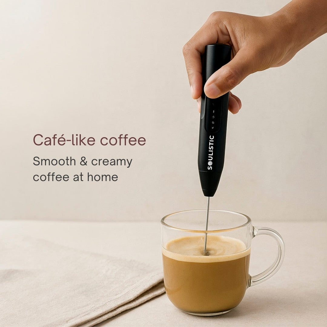 Hand using a milk frother to create foam in a glass of coffee with text 'Café-like coffee' and 'Smooth & creamy coffee at home'.