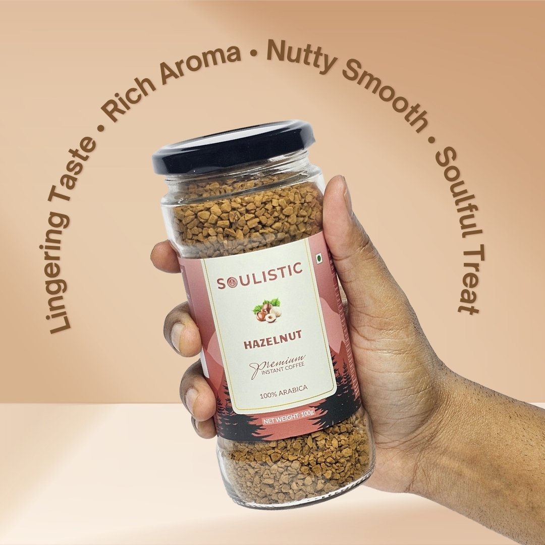 Hand holding a jar of Soulistic Hazelnut coffee with product details on a beige background