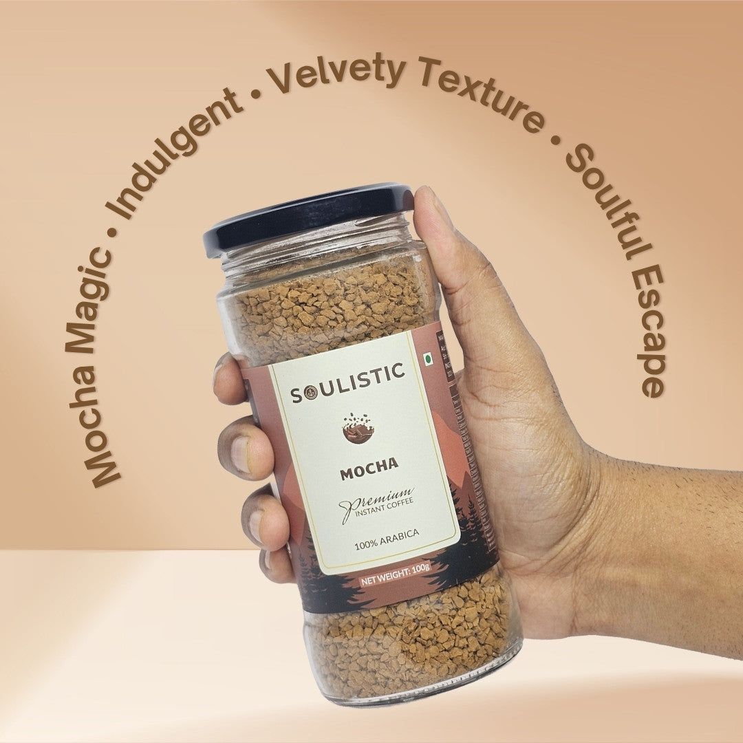 Hand holding a jar of SOULISTIC Mocha coffee against a beige background