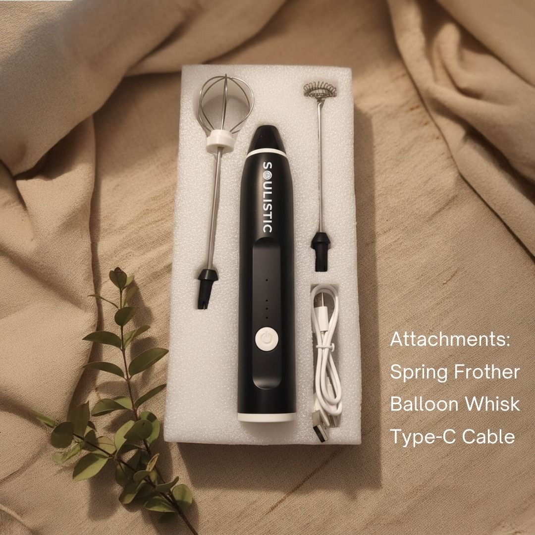 Black Soulistic handheld coffee frother with attachments on a beige fabric background