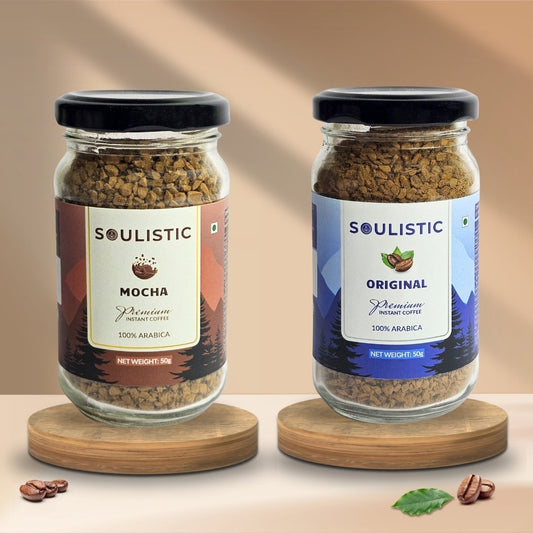 Two jars of Soulistic Mocha and Soulistic Original coffee on wooden stands with a beige background