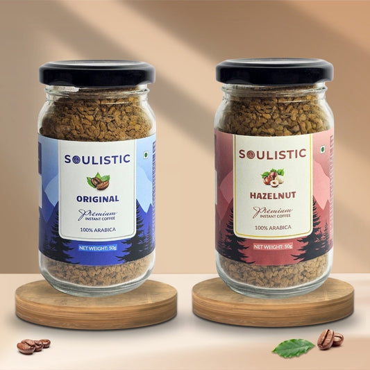Two jars of Soulistic Original and Soulistic Hazelnut coffee on wooden stands with a beige background