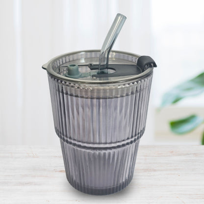 Soulistic ribbed glass sipper with a lid and straw on a light marble surface