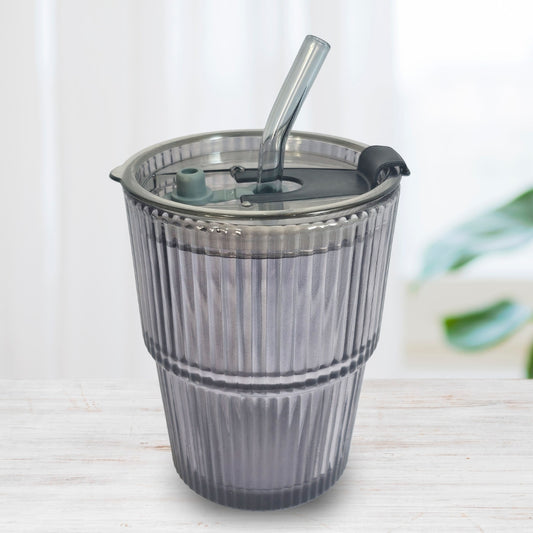 Soulistic ribbed glass sipper with a lid and straw on a light marble surface