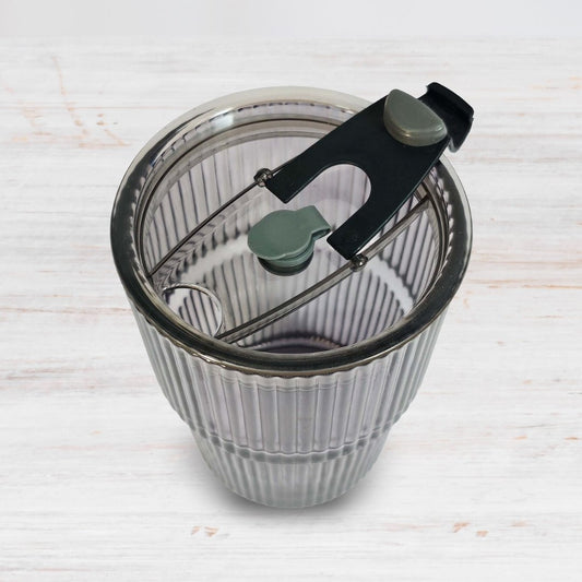 Soulistic ribbed glass sipper with open lid on a light marble surface