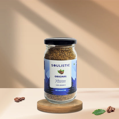 Jar of Soulistic 50g Instant coffee on a wooden coaster with a beige background